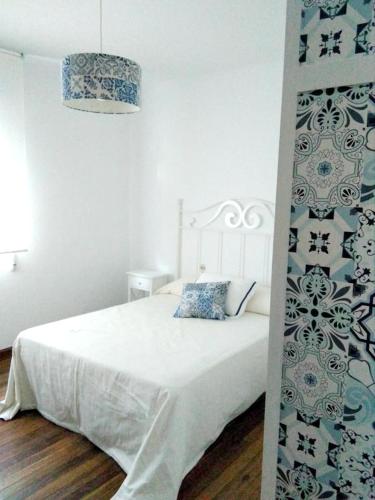 布埃乌4 bedrooms appartement at Bueu的卧室配有白色的床和墙壁