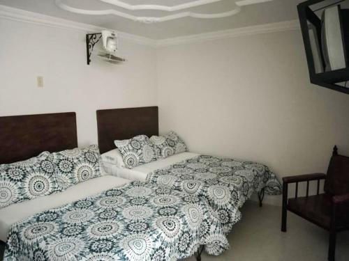图卢阿Hotel Central Johanna的一间卧室配有两张床和椅子