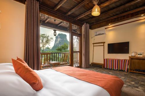 阳朔阳朔碧水间江景度假酒店的一间卧室设有一张床和一个大窗户