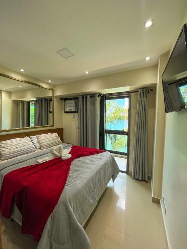 曼加拉蒂巴Apartamento LUXO no Porto Real Resort ao lado da praia的一间卧室配有一张带红色毯子的大床