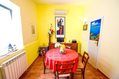 恩纳2 bedrooms house with enclosed garden and wifi at Enna的一间用餐室,配有红色的桌子和椅子