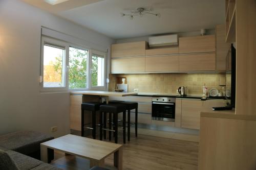 蒂瓦特One bedroom appartement at Tivat 200 m away from the beach with wifi的厨房配有木制橱柜和黑色吧台凳