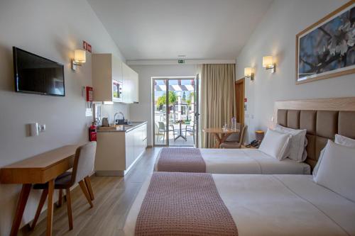 费拉古多Hotel Rural Brícia Du Mar的酒店客房配有两张床和一张书桌