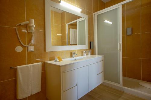费拉古多Hotel Rural Brícia Du Mar的一间带水槽、镜子和淋浴的浴室
