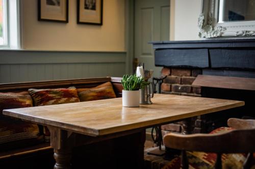 彼得斯菲尔德The Cricketers Inn的客厅配有木桌和钢琴