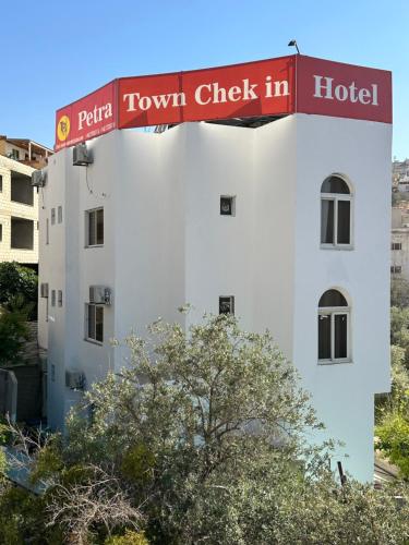 瓦迪穆萨Petra Town Check-Inn的白色建筑,上面有写有城市登记的标志