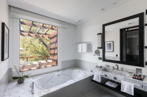 里奥卢汉索菲特的瑞色瓦卡达尔酒店的带浴缸的浴室和大窗户