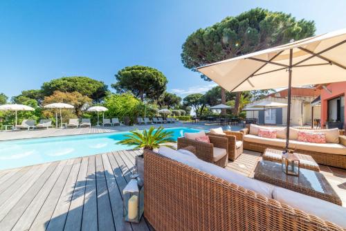 圣特罗佩Les Capucines Saint Tropez的游泳池旁设有家具和遮阳伞的游泳池