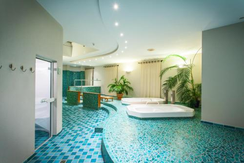 特里尔杜特斯赫尔酒店的浴室配有两个盥洗盆和浴缸。