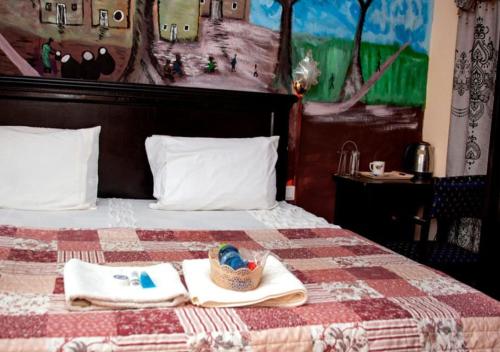 库马西To Be Hotel的一张带两条毛巾和一篮子的床