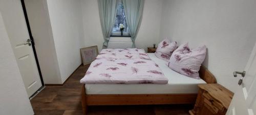 Teschendorfmecklenburgerseenplatt 2的一间卧室配有一张带粉色床单和枕头的床。