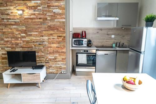 隆河省Le NewYorkais - Appartement 4 pers- Oullins-Lyon的厨房配有不锈钢冰箱和砖墙