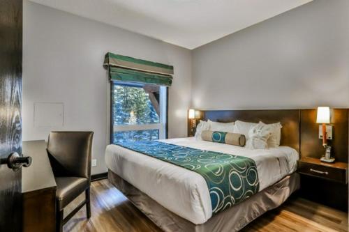 坎莫尔Outstanding Mountain Condo *WATERSLIDE* HOTTUB* hosted by Fenwick Vacation Rentals的卧室配有床、椅子和窗户。