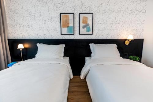 圣保罗Intercity Tatuapé的两张睡床彼此相邻,位于一个房间里
