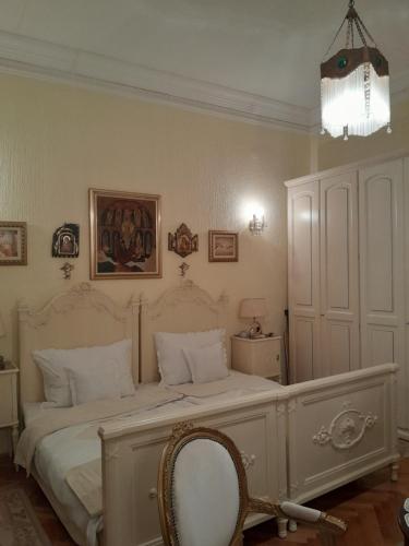 鲁马VILA SREM的卧室配有一张白色大床和椅子