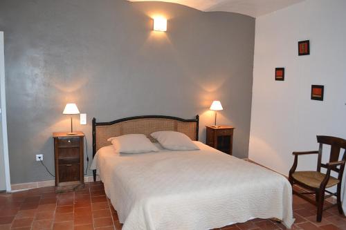 卡伦扎纳a Casa的一间卧室配有一张床、两把椅子和两盏灯。