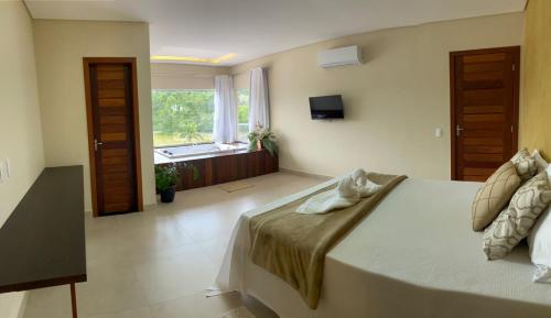 瓜拉派瑞Pousada Peninsula Santa Rita的一间卧室设有一张大床和一个窗户。