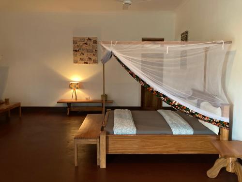 Mikumi巴斯蒂安营米库米度假屋的一间卧室配有一张带蚊帐的床