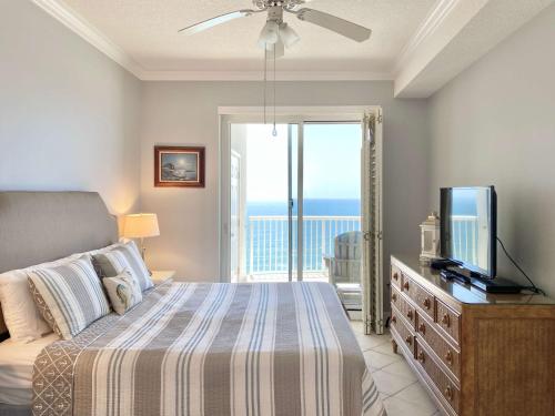 格尔夫海岸Island Royale P103 by ALBVR - Beachfront Penthouse living at its best - Gorgeous views的一间卧室设有一张带电视的床和一个阳台。