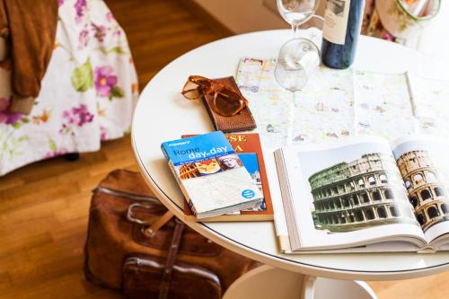 罗马帕格尼尼住宿加早餐旅馆的一张带书籍的白色桌子和葡萄酒杯