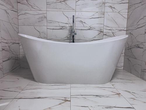 斯托尼拉斯奇Agroturystyka u Maryli的浴室铺有大理石瓷砖,配有白色浴缸。