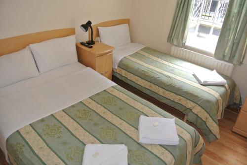 伦敦贝尔格罗夫酒店的酒店客房设有两张床和窗户。