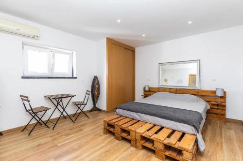 马夫拉Moments Villa的卧室配有一张床和一张桌子及椅子