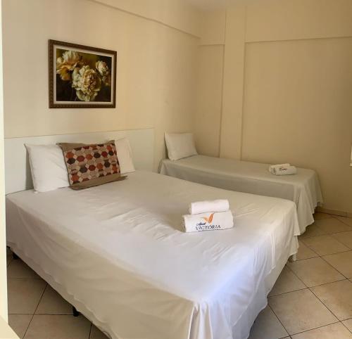 维多利亚-达孔基斯塔Apart Victoria的配有白色床单的客房内的两张床
