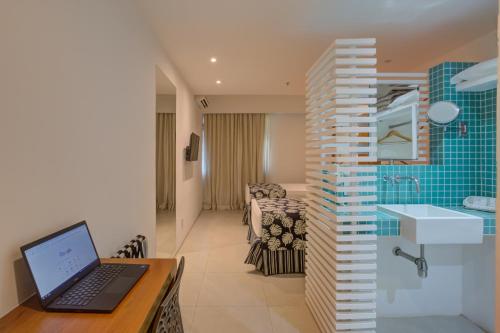 里约热内卢Rio Design Copacabana Hotel的客房设有带笔记本电脑的书桌和浴室