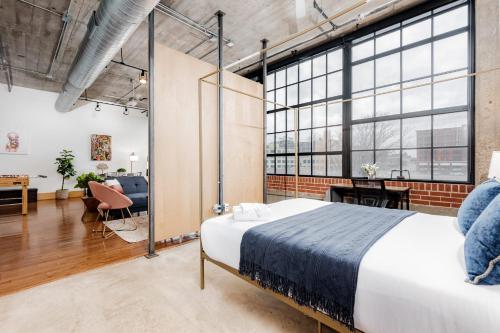 圣路易斯CozySuites Stunning 1BR Adler Loft with Parking的一间带大床的卧室和一间客厅