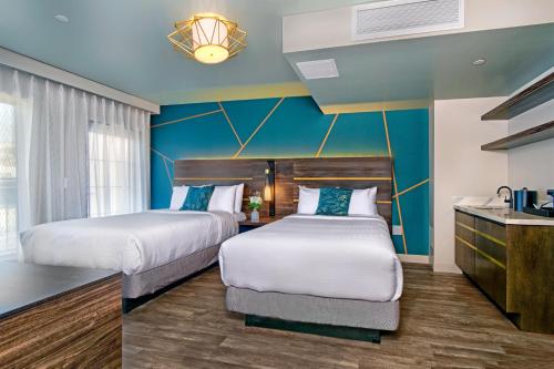 圣克鲁兹Marea Sol Hotel的两张位于酒店客房的床,拥有蓝色的墙壁