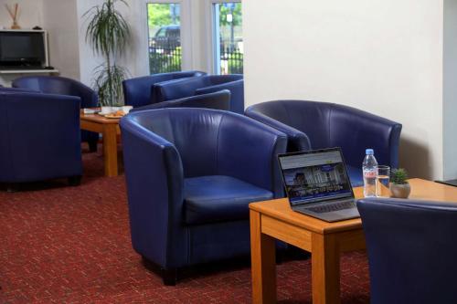 伦敦贝斯特韦斯特伦敦海布里酒店的一间设有蓝色椅子和一张桌子上的笔记本电脑的等候室