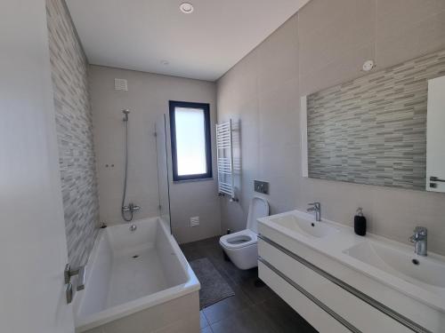 邦巴拉尔Villa Joia的一间带两个盥洗盆、浴缸和卫生间的浴室
