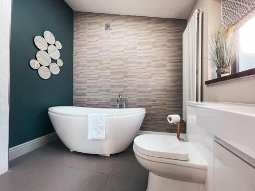 卡迪夫Ty Fry Gardens的浴室配有白色浴缸和卫生间。