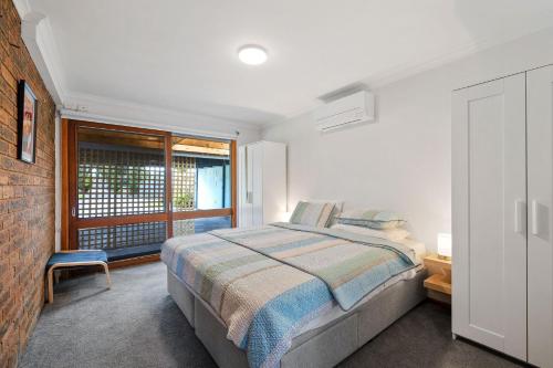 卡尔斯Redwood Beach House - with 10 percent off until September的白色的卧室设有床和窗户