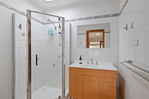 卡尔斯Redwood Beach House - with 10 percent off until September的带淋浴和盥洗盆的白色浴室