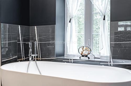 SheffordB&B Suite INN Abondance & SPA的带窗户的浴室内的白色浴缸