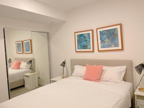 布里斯班Cosy and Stylish 1 BD Serviced Apt at SouthBank的一间卧室配有两张床和镜子