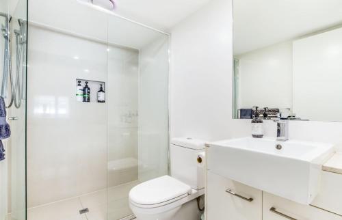 布里斯班Luxurious 3BDR Townhouse in Great Location的带淋浴、卫生间和盥洗盆的白色浴室