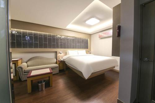 庆州Sugar Hotel的酒店客房,配有床和沙发