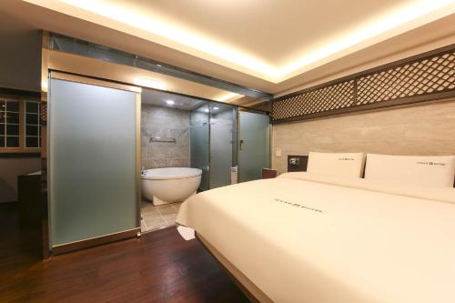 庆州Sugar Hotel的一间卧室设有一张大床和一个浴缸