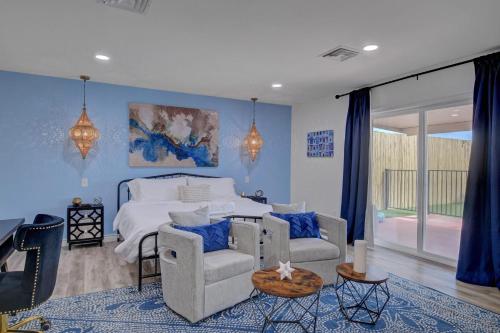 拉斯维加斯Buddha Mansion Luxury Resort - 8BR Modern, HotTub, Huge pool, Sauna, BBQ grill, Game Room的一间卧室配有一张带蓝色墙壁和椅子的床。