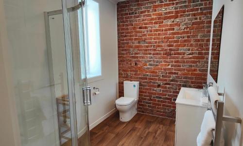 因弗卡吉尔Historic Inner City Apartment的一间带卫生间和砖墙的浴室