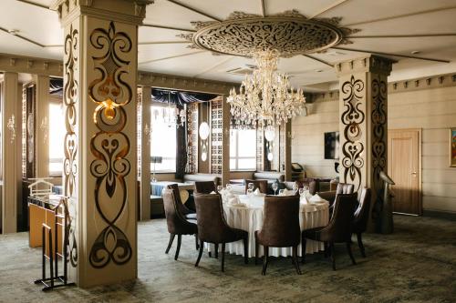 阿斯塔纳姜巴塔阿斯塔纳酒店的一间带桌椅和吊灯的用餐室