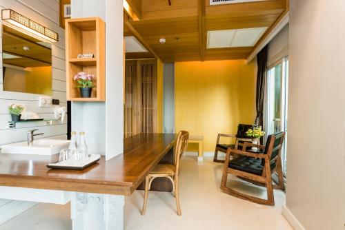 曼谷Dang Derm In The Park Khaosan的一间带木桌和椅子的用餐室