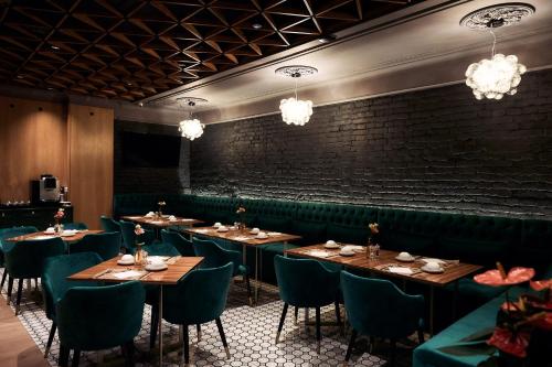萨图马雷HOTEL VIENA的一间带桌椅的餐厅以及砖墙