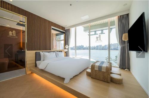 釜山De Homme Hotel的一间卧室设有一张床和一个大窗户