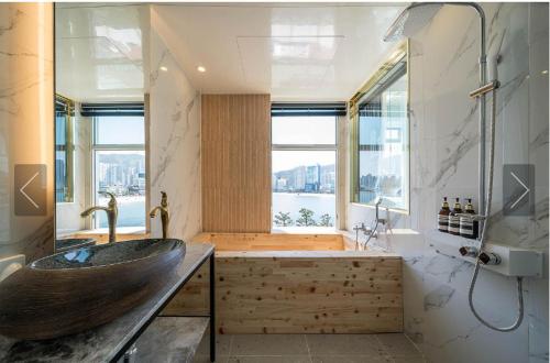 釜山De Homme Hotel的一间带木制水槽和大窗户的浴室