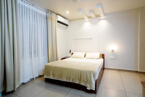 埃尔讷古勒姆Kadampanattu's Homestay的一间卧室设有一张床和一个大窗户