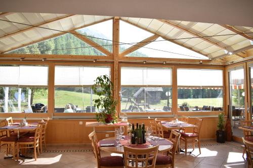 兰达Restaurant & Hostel Hole in One的用餐室设有桌椅和窗户。
